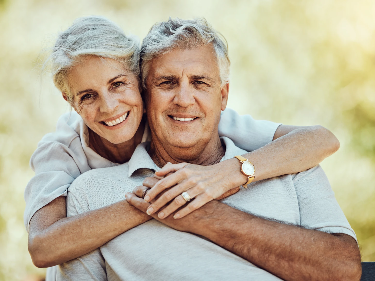 Older couple smiling together after dental implants in Baltimore